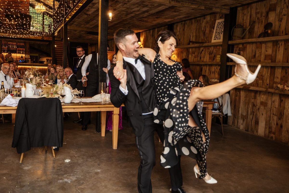hidden river barn groomsmen dancing with guests ceremony room