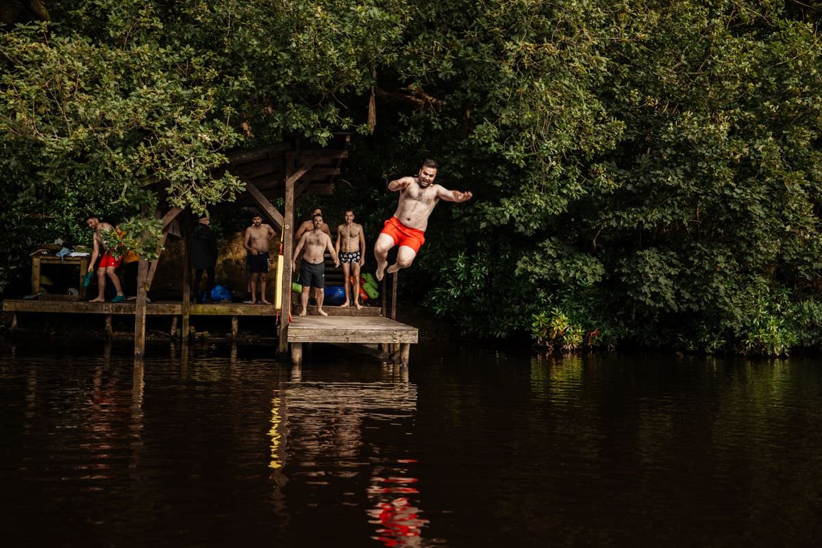 groom jumping in lake at wyresdale park wedding venue