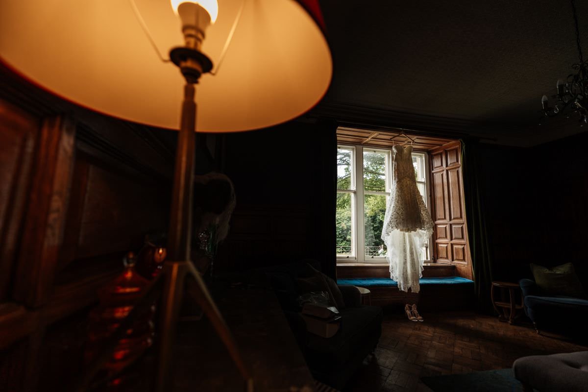 wedding dress hanging in window at wyresdale park wedding photography 