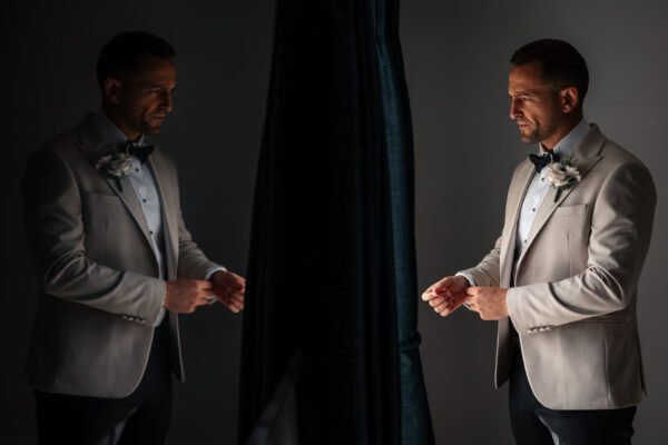reflection window groom suit flowers