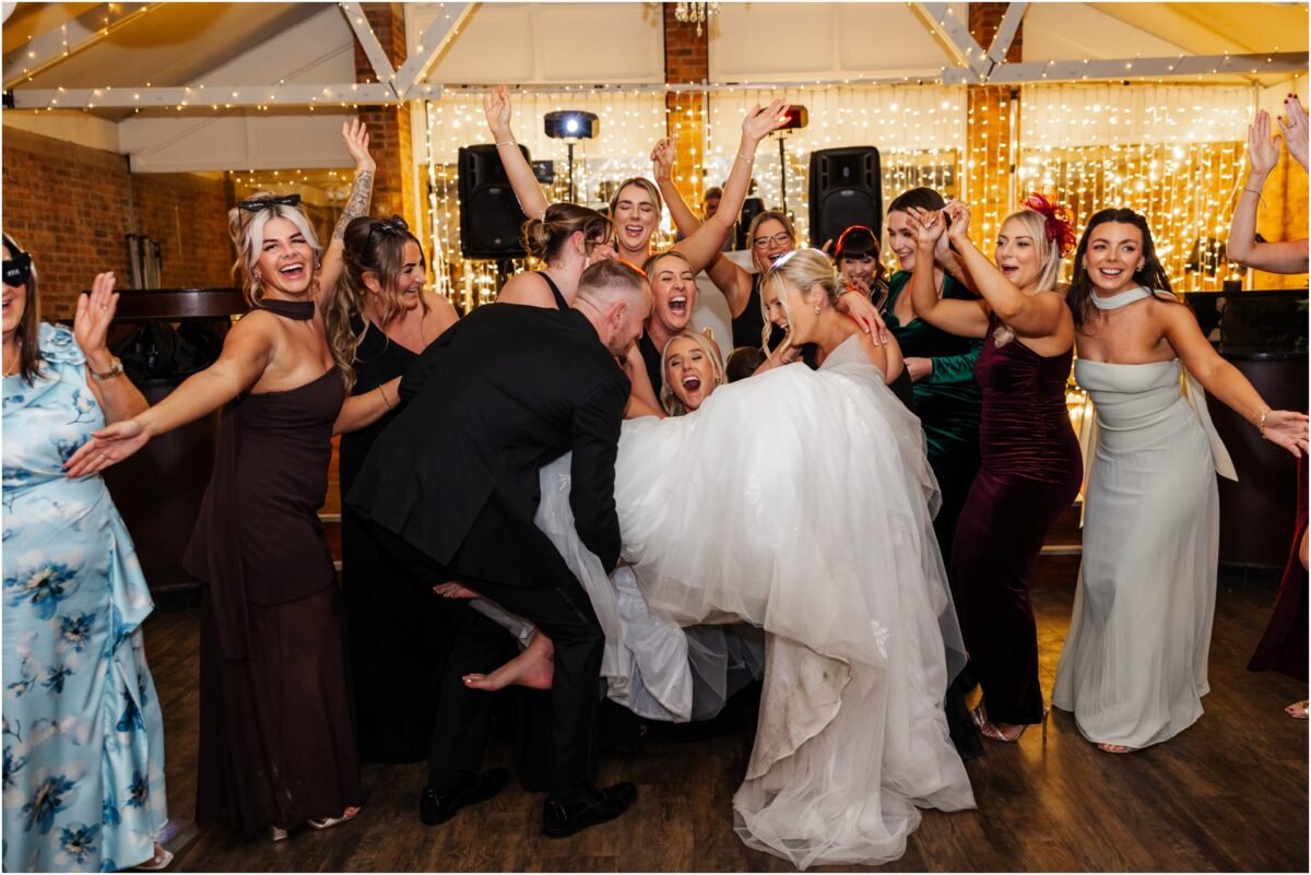 lifing the bride up surronded by wedding party 
