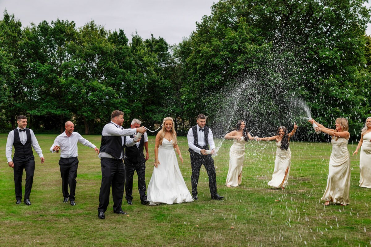 Champagne spray wedding guests garden evening bartle hall