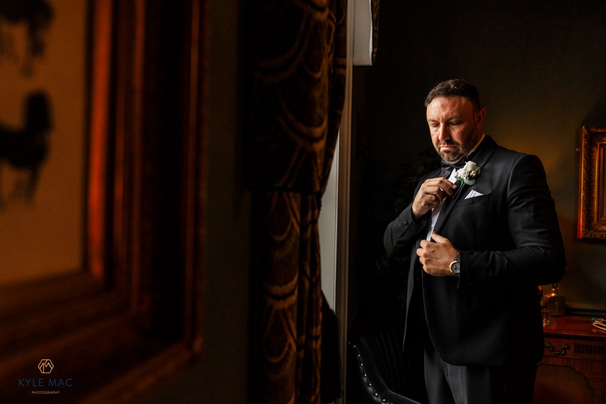 groom preparation flowers black suit