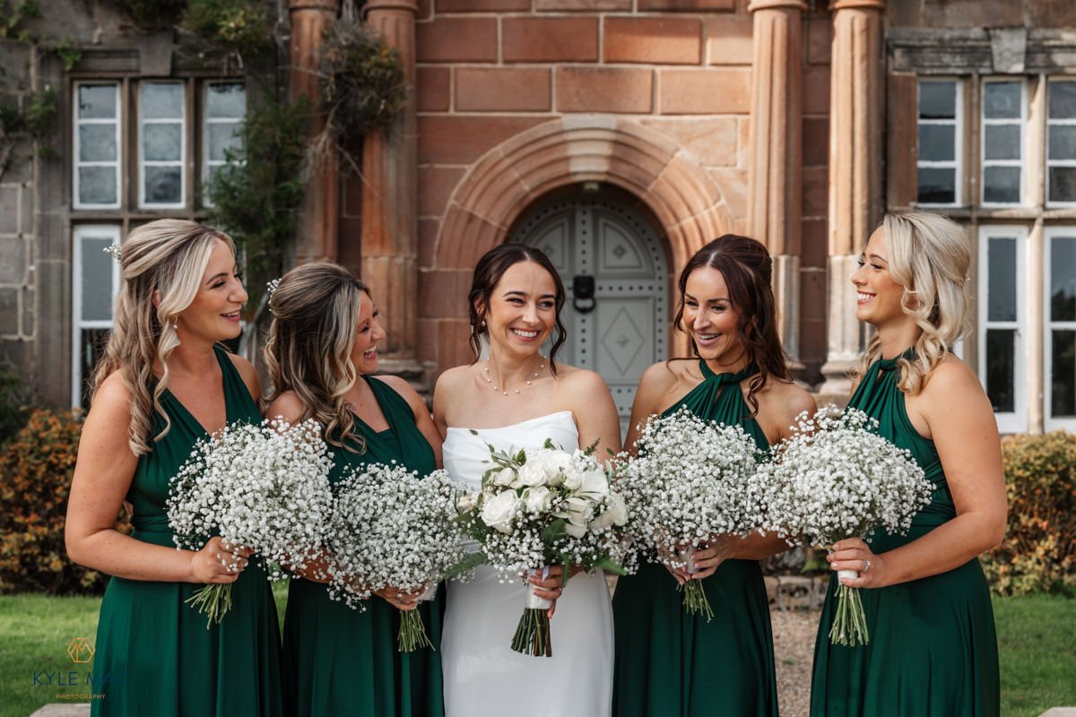Bridesmaids laughing together in deep green dresses, Ribble Valley wedding