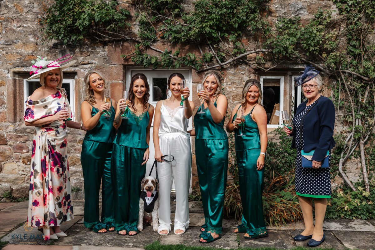Bride with her bridesmaids in green dresses outside Browsholme Hall